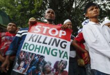 Bangladesh Rescues Rohingya Illegally Heading for Malaysia An ethnic Rohingya holds a banner during protest after Friday prayers outside the Myanmar Embassy in 2016 in Kuala Lumpur, Malaysia. Photo: Vincent Thian / Associated Press