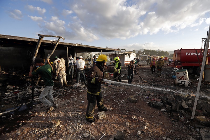 Firefighters and local residents work at the scorched ground of the open-air San Pablito fireworks market, Tuesday in Tultepec, outskirts of Mexico City, Mexico. Photo: Eduardo Verdugo / Associated Press