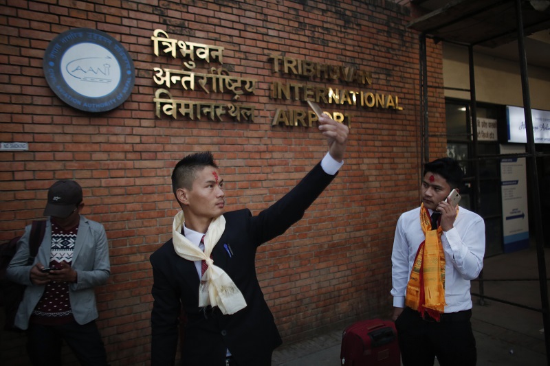 A Nepali Prem Bahadur Ale Magar, 23, takes a selfie in November while he waits for his flight to Malaysia, where he will work in a warehouse as a cleaner, at Tribhuwan International airport in Kathmandu, Nepal. Photo: Niranjan Shrestha / Associated Press