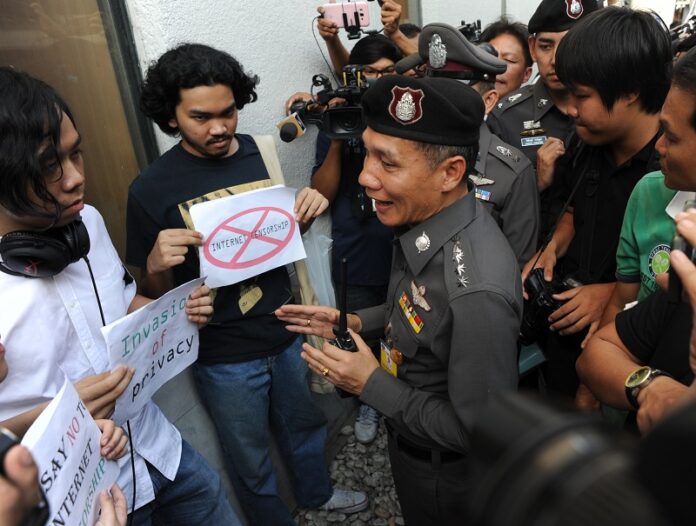 Police speak to activists protesting the new Computer Crime Act on Sunday at the Bangkok Art and Culture Centre.