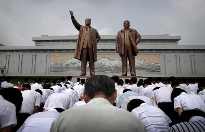 North Koreans in a 2015 photo file bow in front of bronze statues of the late leaders Kim Il Sung, left, and Kim Jong Il at Munsu Hill in Pyongyang, North Korea. Photo: Wong Maye-E / Associated Press