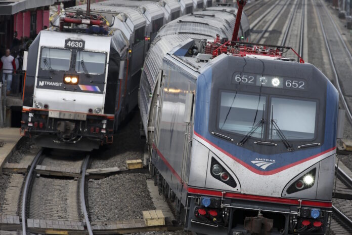 A file photo of an Amtrak train passes a New Jersey Transit train. Photo: Mel Evans / AP.