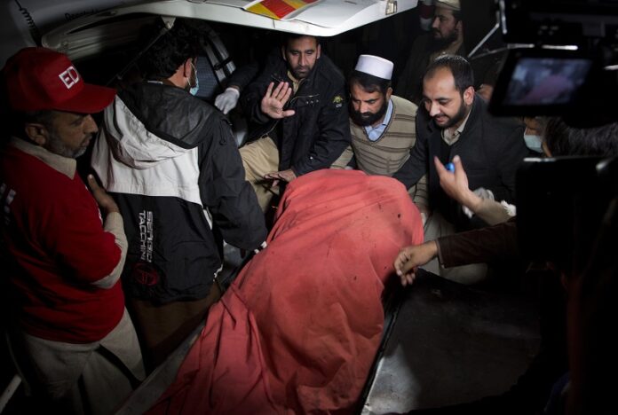 Pakistani volunteers move remains of plane crash victims to a mortuary Wednesday at a hospital, in Abbottabad, Pakistan. Photo: B.K. Bangash / Associated Press