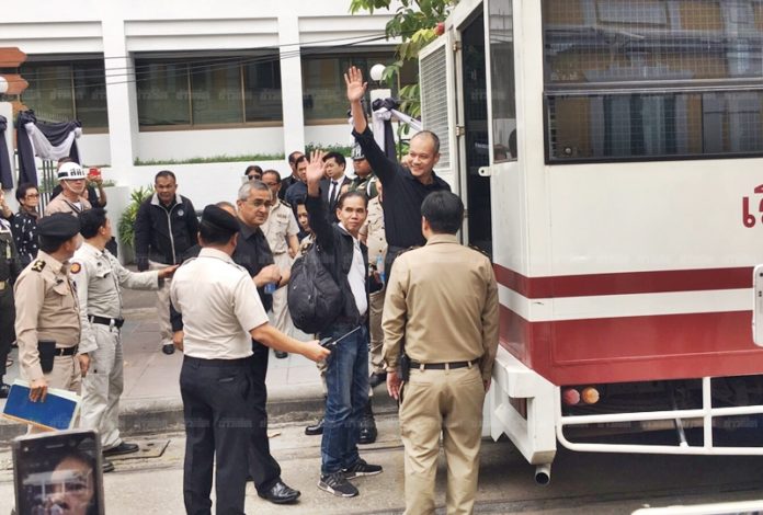 Red Shirt leader wave their hands to media while they are taken from military court to Bangkok Remand Prison Friday.