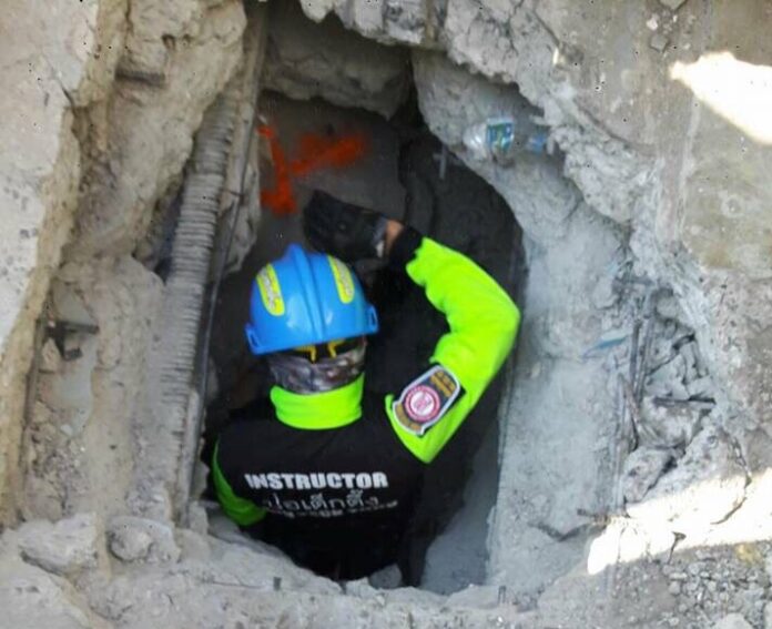 A rescue worker enters the rubble of a collapsed building Sunday in Bangkok’s Soi Sukhumvit 87.