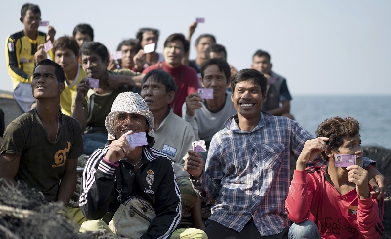 Crew from a fishing boat show their identity cards to Thai navy officers during a search of their boat in the waters off the coast of Samut Sakhon province. Photo: Dake Kang / Associated Press