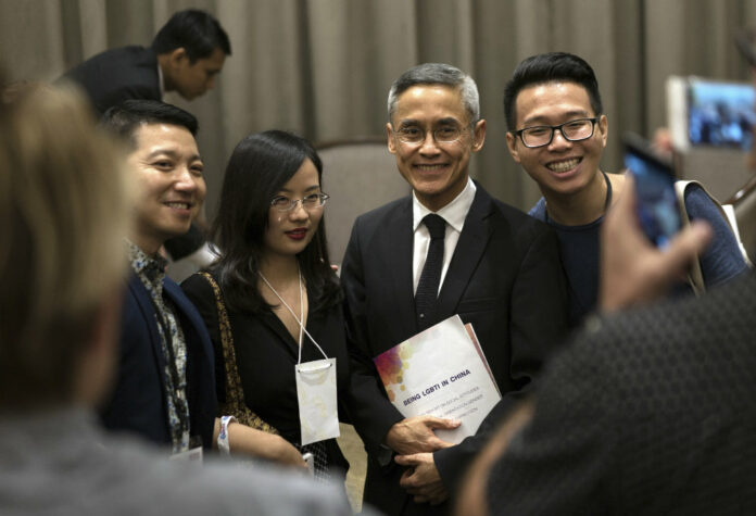 Vitit Muntarbhorn Thai legal expert and the first-ever U.N. independent expert, center, poses for a photo with delegates from China at a LGBT conference in Bangkok, Thailand. Photo: Dake Kang / AP.
