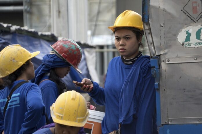 In this Monday Dec. 12, 2016 photo, a Cambodian migrant construction worker waits for transport home outside a building site site in downtown Bangkok, Thailand. Photo: Dake Kang / Associated Press