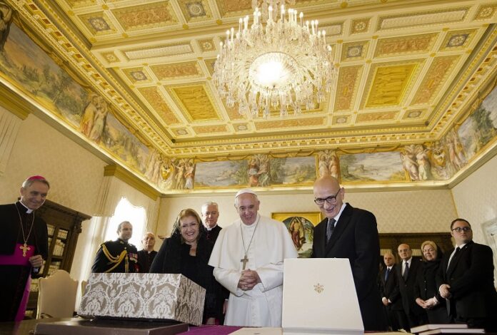 Pope Francis exchanges gifts with President of Malta, Marie Louise Coleiro Preca, left, and her husband Edgar, right, Saturday during a private audience at the Vatican. Photo: Claudio Peri / Associated Press