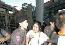 Pro-Democracy Activist Flees Prosecution For Royal Insult Chanoknan Ruamsap being removed from a protest and taken into custody.