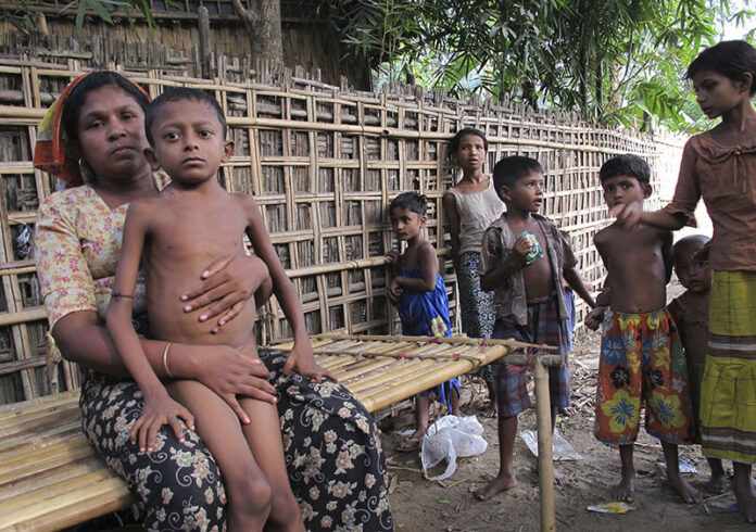 Salema Khatu, at left, wraps her arms around her son Habil, who was suffering from tuberculosis in an area for Rohingya refugees on May 8, 2014, in north of Sittwe, western Rakhine state, Myanmar. Photo: Robin McDowell / Associated Press