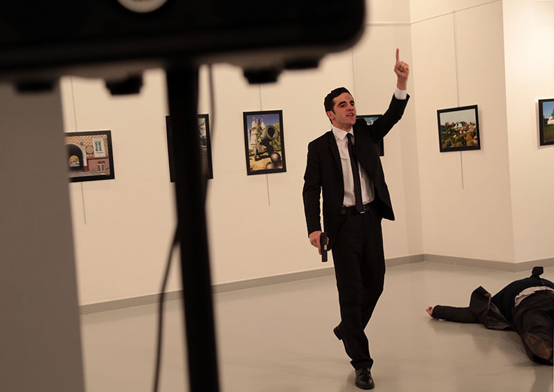 A man suspected of shooting Russian ambassador to Turkey Andrei Karlov gestures as Karlov lies on the ground at a photo gallery on Monday in Ankara, Turkey. Photo: Burhan Ozbilici / Associated Press