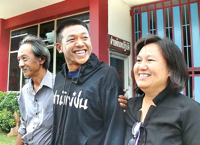 Jatupat ‘Pai’ Boonpattararaksa poses with his parents Aug. 24 in front of the Khon Kaen military court upon being freed on bail in another court case.
