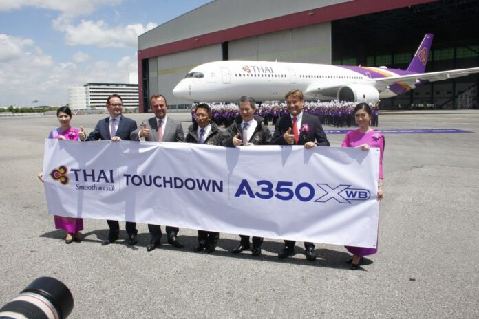 Thai Airways officials pose for a photo on Aug. 31 at Suvarnabhumi Airport at a publicity event for its new aircraft outfitted with Rolls Royce-made engines.