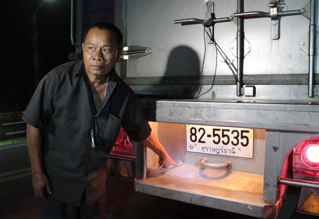 Prasong Hun-ngam points to a bullet hole in his truck.