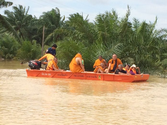 Monks on a boat Thursday after their temple flooded in Surat Thani.