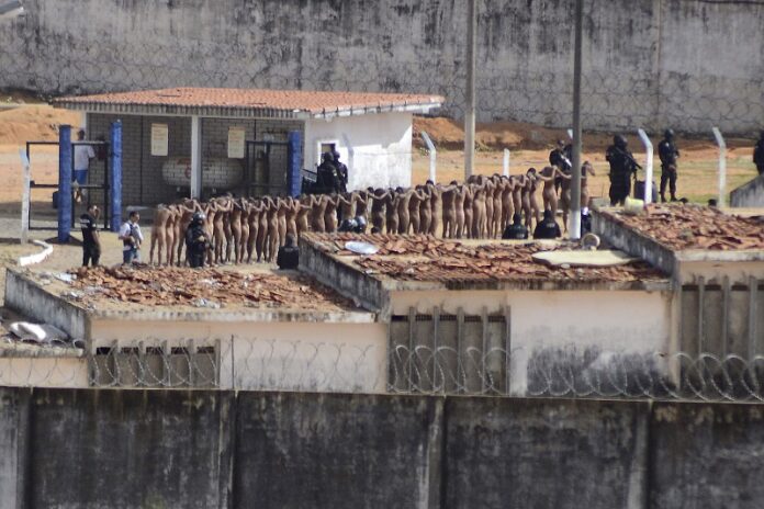 Naked inmates stand in line while surrounded by police after a riot at the Alcacuz prison Sunday in Nisia Floresta, Rio Grande do Norte state, Brazil. Photo: Frankie Marcone / Associated Press