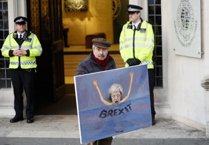 Painter Kaya Mar shows his latest painting of British Prime Minister Theresa May in 2017 in front of the Supreme Court in London: Photo: Frank Augstein / Associated Press