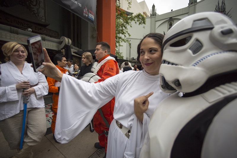 Costumed fan Natalie Benavides, dressed as Princess Leia, in honor of actress Carrie Fisher, who played Leia in the "Star Wars" movie series, takes a selfie at a memorial in the forecourt at the TCL Chinese Theatre in the Hollywood section of Los Angeles, Saturday, Dec. 31, 2016. Fisher had been hospitalized since Dec. 23 after falling ill aboard a flight and being treated by paramedics at the Los Angeles airport. Photo: Damian Dovarganes / Associated Press