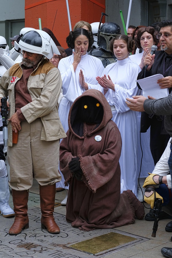 Costumed fans gather for a moment of silence for actress Carrie Fisher in the forecourt at the TCL Chinese Theatre in the Hollywood section of Los Angeles on Saturday. Photo: Richard Vogel / Associated Press