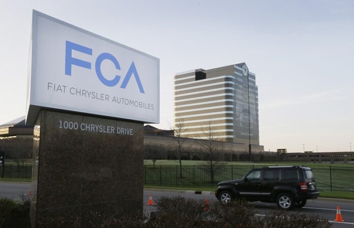 A vehicle moves past a sign outside Fiat Chrysler Automobiles world headquarters in 2014 in Auburn Hills, Michigan. Photo: Carlos Osorio / Associated Press
