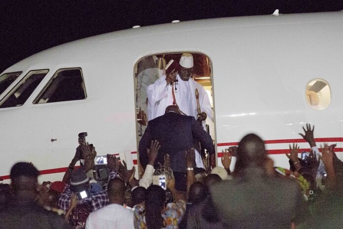 Gambia's defeated leader Yahya Jammeh waves to supporters as he departs Saturday at Banjul airport. Photo: Jerome Delay / Associated Press