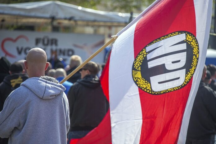 A man with a flag with National Democratic Party, NPD, logo attends a rally of the NPD last May in Schwerin, Germany. Photo: Jens Buettner / Associated Press