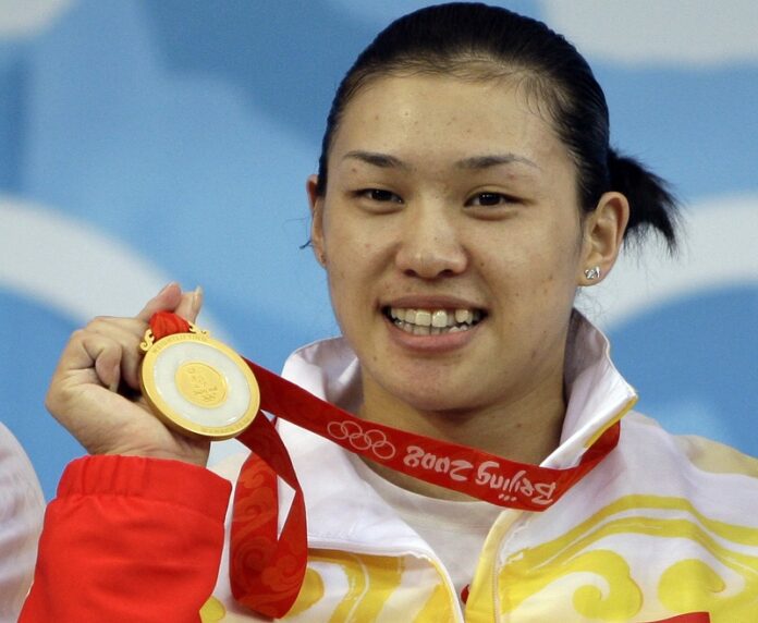 Cao Lei, of China, holds up her gold medal in the women's 75 kg. of the weightlifting competition at the Beijing 2008 Olympics in Beijing, China. Photo: Andres Leighton / Associated Press