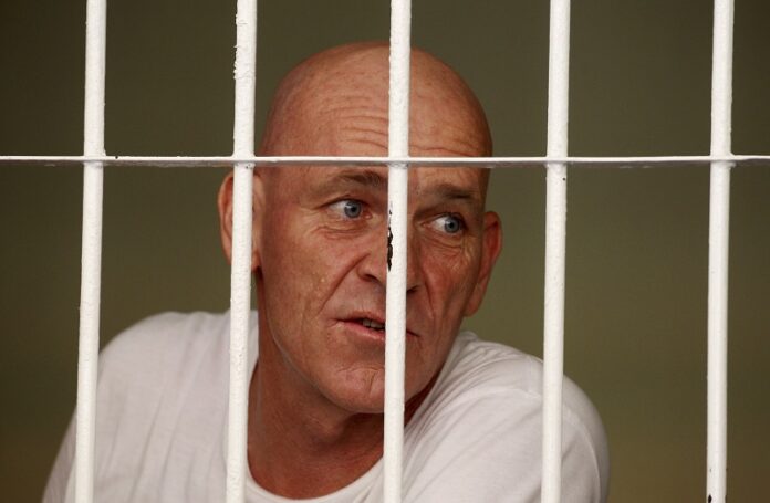 British national and former news correspondent David Fox inside his cell speaks to his lawyer Thursday after his trial in Bali, Indonesia. Photo: Firdia Lisnawati / Associated Press