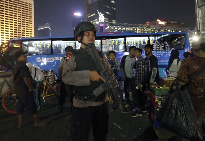 An Indonesian police officer stands guard prior to the New Year's celebration at the main business district in December in Jakarta, Indonesia. Photo: Tatan Syuflana / Associated Press