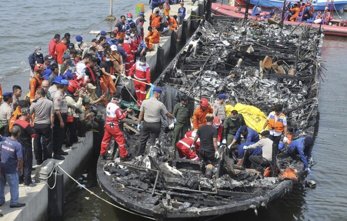Rescuers search for victims from the wreckage of a ferry that caught fire off the coast of Jakarta after it was docked on Sunday at Muara Angke Port in Jakarta, Indonesia. Photo: Rhana Ananda / Associated Press