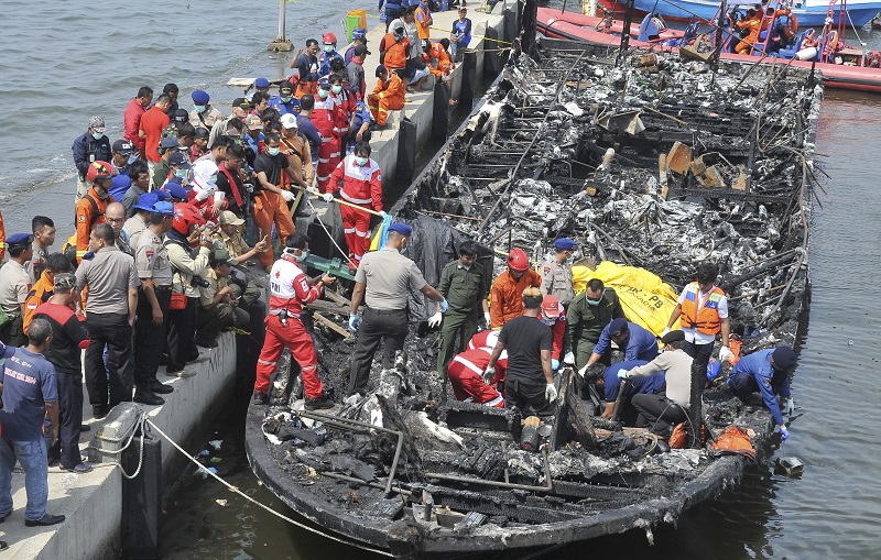 Rescuers search for victims from the wreckage of a ferry that caught fire off the coast of Jakarta after it was docked on Sunday at Muara Angke Port in Jakarta, Indonesia. Photo: Rhana Ananda / Associated Press