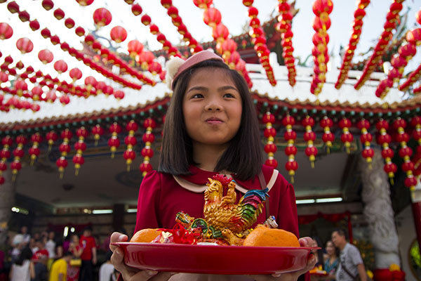 Malaysia: An ethnic Chinese girl holds offerings on the first day of Lunar New Year celebrations Saturday at a temple in Kuala Lumpur. Photo: Lim Huey Teng / Associated Press
