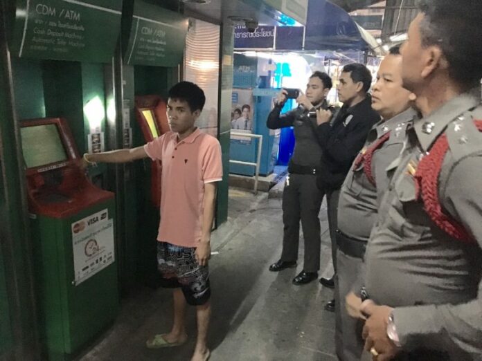 Srawut Pungprasop, shows police the ATM he was using when he got robbed midnight Tuesday in Bang Khen.
