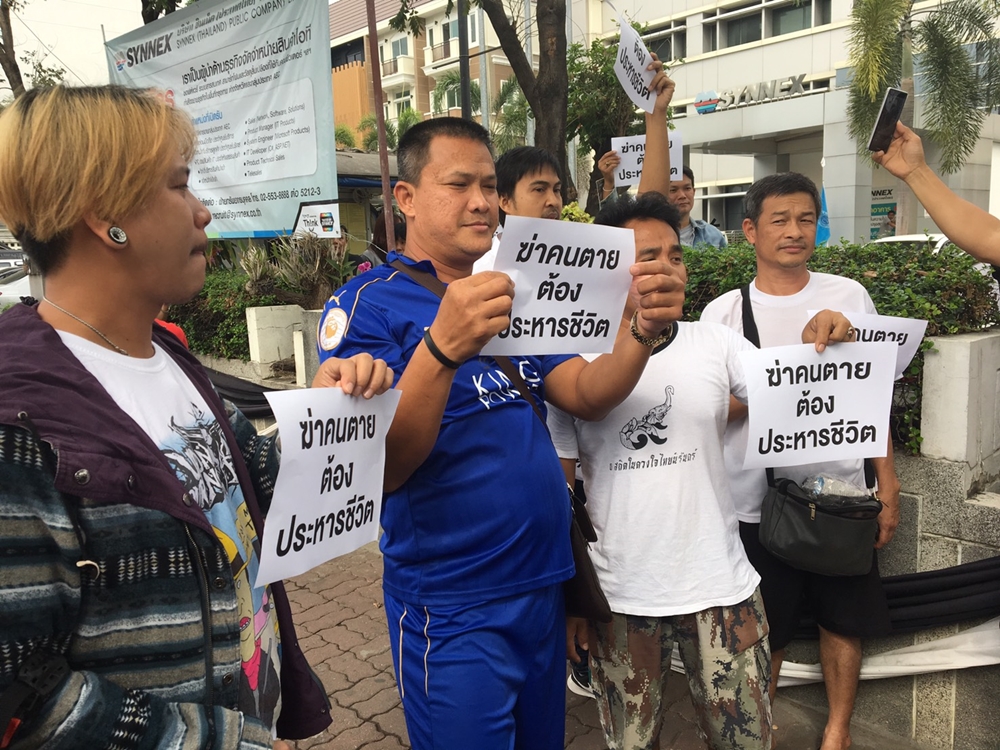 People display signs demanding Kittkorn be executed. 