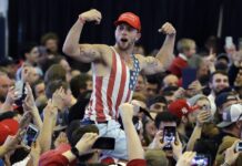 Congress OKs Border Deal; Trump Will Sign, Declare Emergency A Donald Trump supporter flexes his muscles in 2017 with the words "Build The Wall" written on them as Trump speaks at a campaign rally in Plattsburgh, New York. Photo: Elise Amendola / Associated Press
