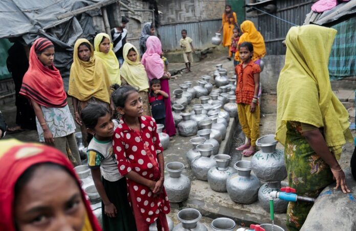 Rohingya women and children wait in a queue to collect water in December at the Leda camp, an unregistered camp for Rohingya in Teknaf, near Cox's Bazar, a southern coastal district about, 296 kilometers (183 miles) south of Dhaka, Bangladesh. Photo: Associated Press