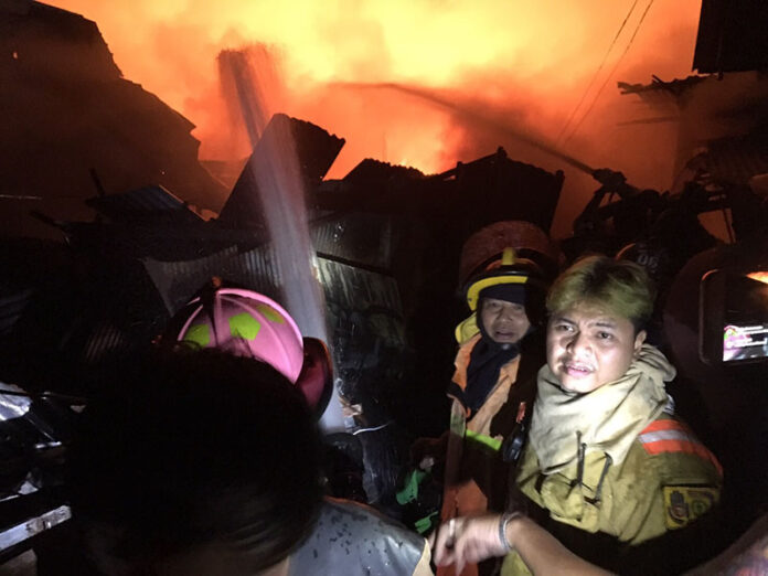 Firefighters at the scene of a fire Friday night in the capital's Khlong Toei district.