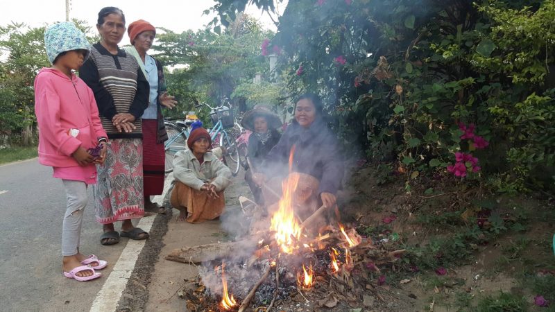 Residents of Buriram province burn wood for heat Saturday.