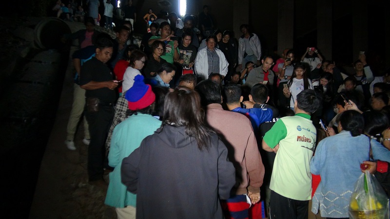 People surround the reportedly possessed woman near the site of the five ta-khian trees.