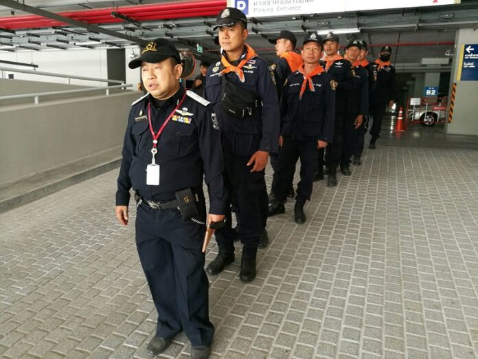 DSI officials on Friday line up at the Centennial Building at Wat Dhammakaya as the search for former abbot Dhammachayo enters its second day.