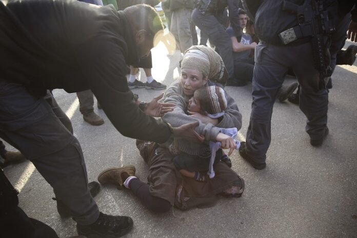 Israeli police on Thursday evicts settlers from the West Bank settlement of Ofra, following the evacuation of Amona outpost. Photo: Oded Balilty / Associated Press
