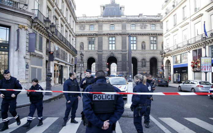 Police officers cordon off the area next to the Louvre museum in Paris Friday. Photo: Thibault Camus / AP.