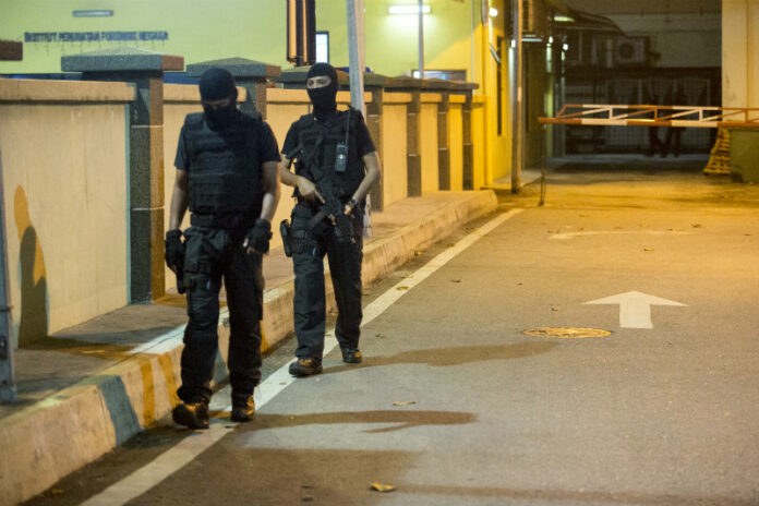 Special Task Force On Organised Crime (STAFOC) police patrol at the National Forensic Institute at Kuala Lumpur Hospital in Kuala Lumpur, Malaysia, Tuesday. Photo: Alexandra Radu / AP