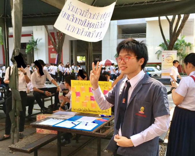 Student activist Netiwit Chotiphatphaisal at a petition booth to oppose dress code rules Wednesday. Photo: Pakpoom Joe Thaweesitthichat / Facebook