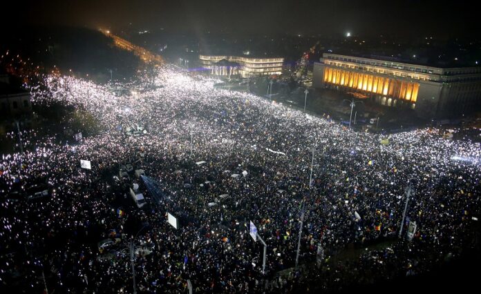 Tens of thousands of people gather for a demonstration Sunday in front of the government building in Bucharest, Romania. Photo: Darko Bandic / Associated Press