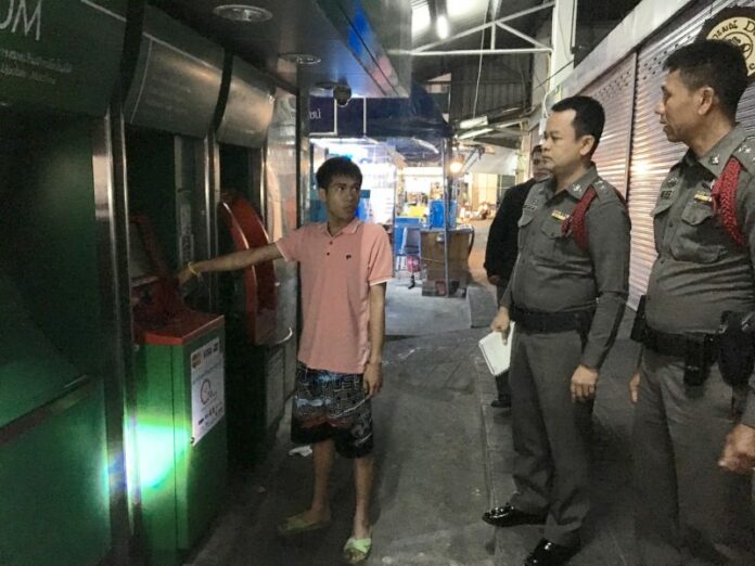 Srawut Pungprasop, shows police the ATM he claimed to be using when he was allegedly robbed Tuesday night in Bang Khen.