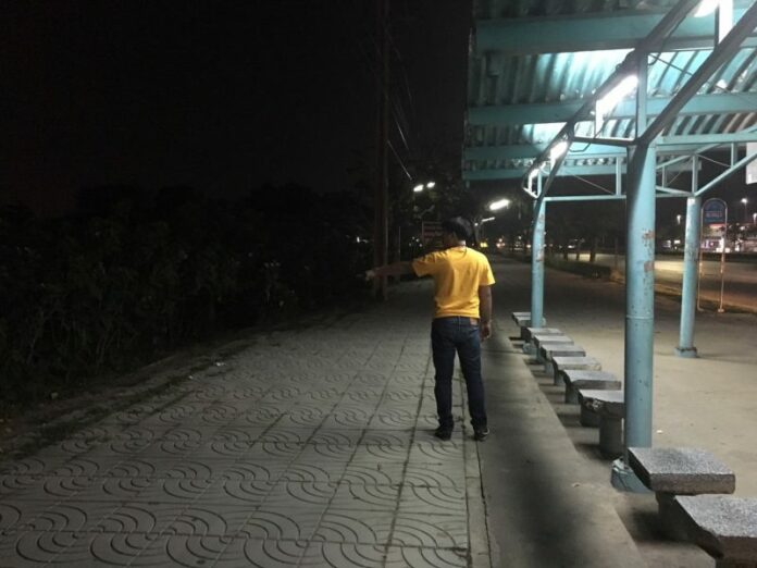 An officer points to a grassy area where Suppakorn Kampol attempted to rape a woman Monday midnight on Phahon Yothin Road.