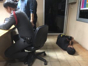 In a state of inebriation, Suppakorn Kampol, right, lies on the floor Monday at Don Mueang Police Station after being arrested for allegedly attempting to rape a woman. 