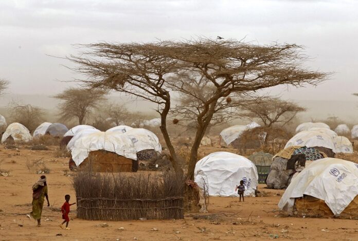 Refugees walk amongst huts at a refugee camp in 2011 in Dadaab, Kenya. Photo: Schalk van Zuydam / Associated Press